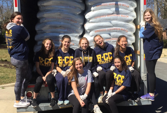 B-CC girls sitting on truck with bags of mulch